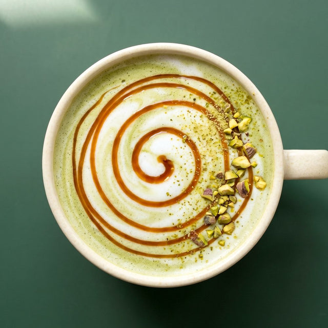 Pistachio matcha latte with caramel and chopped pistachios